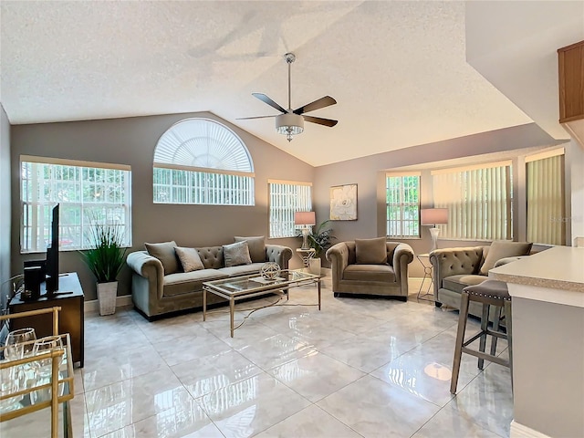 living room featuring ceiling fan, a textured ceiling, and vaulted ceiling