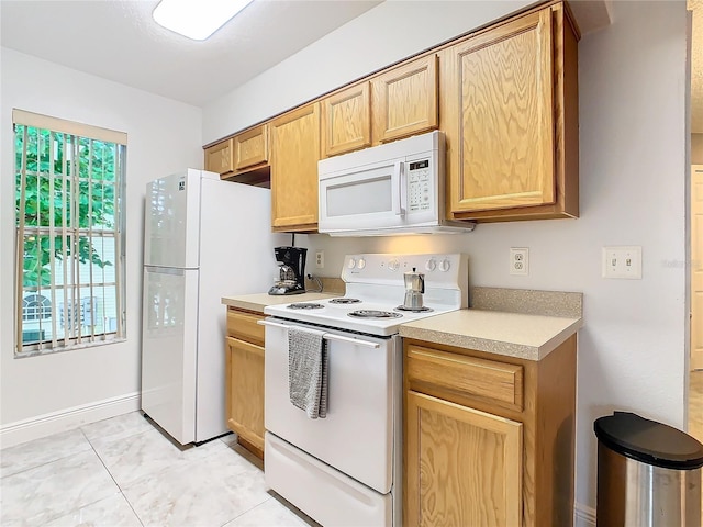 kitchen with light tile patterned floors and white appliances