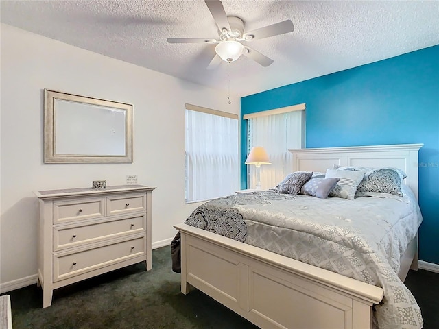 bedroom with ceiling fan, a textured ceiling, and dark colored carpet