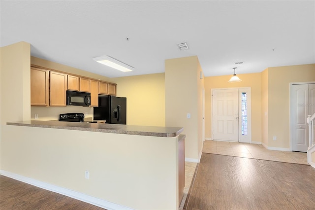 kitchen with pendant lighting, light brown cabinets, black appliances, light hardwood / wood-style flooring, and kitchen peninsula