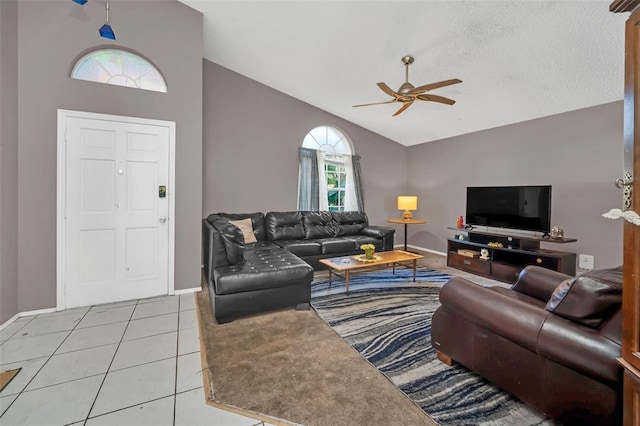 tiled living room featuring ceiling fan, high vaulted ceiling, and a textured ceiling