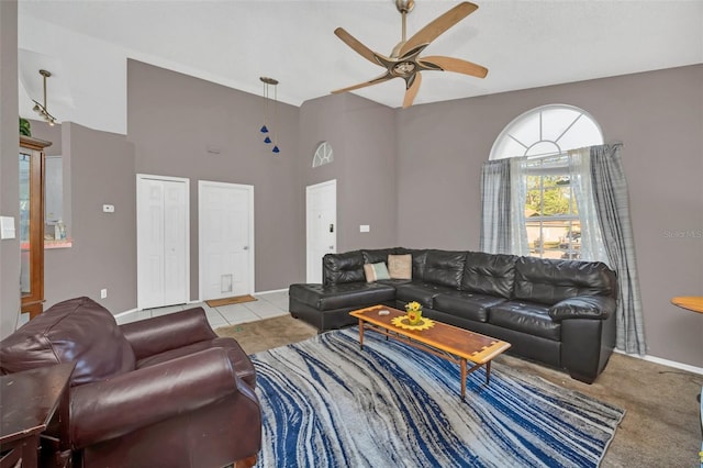 living room with a towering ceiling, light colored carpet, and ceiling fan