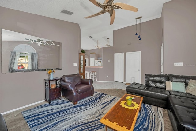 tiled living room featuring a textured ceiling, ceiling fan, and lofted ceiling