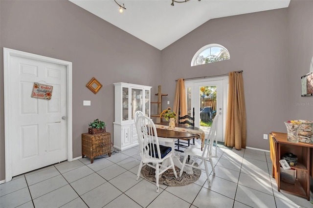 dining space featuring light tile patterned floors and high vaulted ceiling