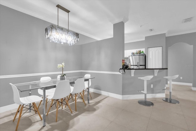 dining area featuring crown molding, light tile patterned floors, and a chandelier