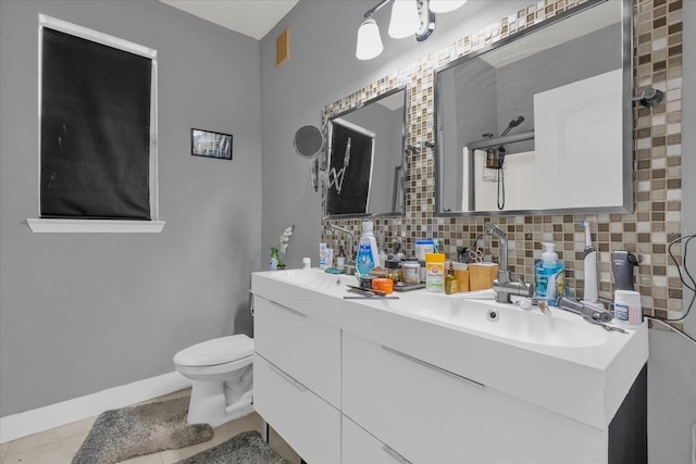 bathroom with tile patterned floors, vanity, toilet, and tasteful backsplash