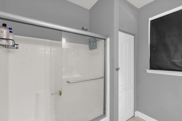 bathroom featuring a shower with door