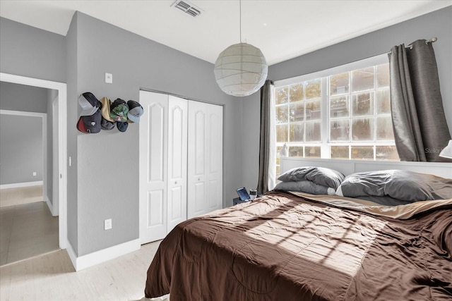 bedroom with light hardwood / wood-style floors and a closet