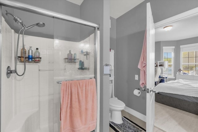 bathroom with toilet and a shower with shower door