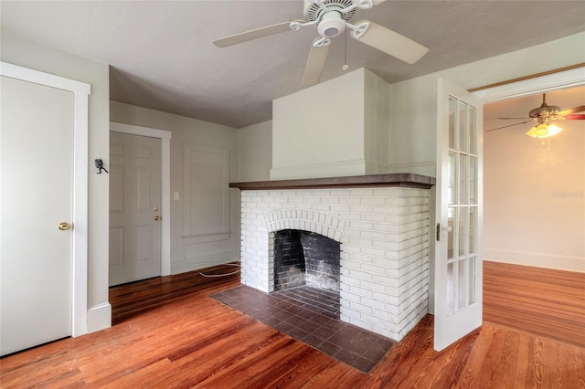 unfurnished living room featuring ceiling fan, hardwood / wood-style floors, and a fireplace