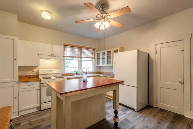 kitchen with hardwood / wood-style floors, white appliances, a center island, and white cabinets