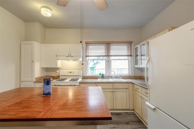 kitchen with wood-type flooring, sink, white appliances, and wood counters