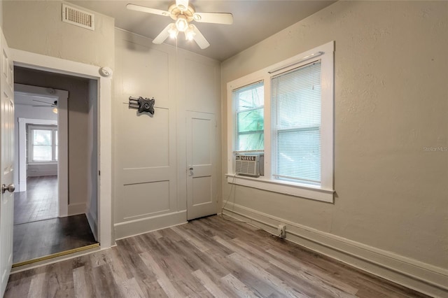 unfurnished room featuring wood-type flooring, cooling unit, and ceiling fan