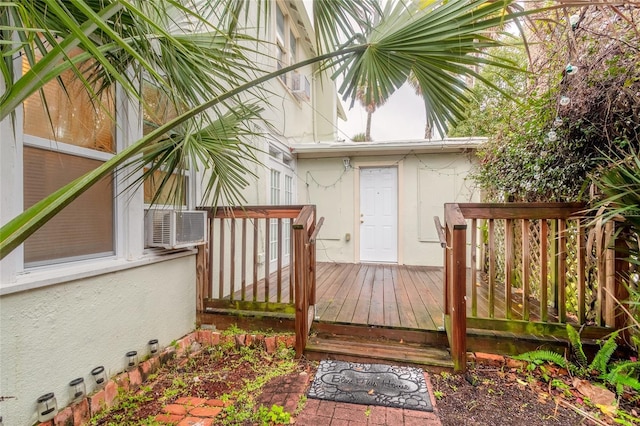 doorway to property with a wooden deck and cooling unit