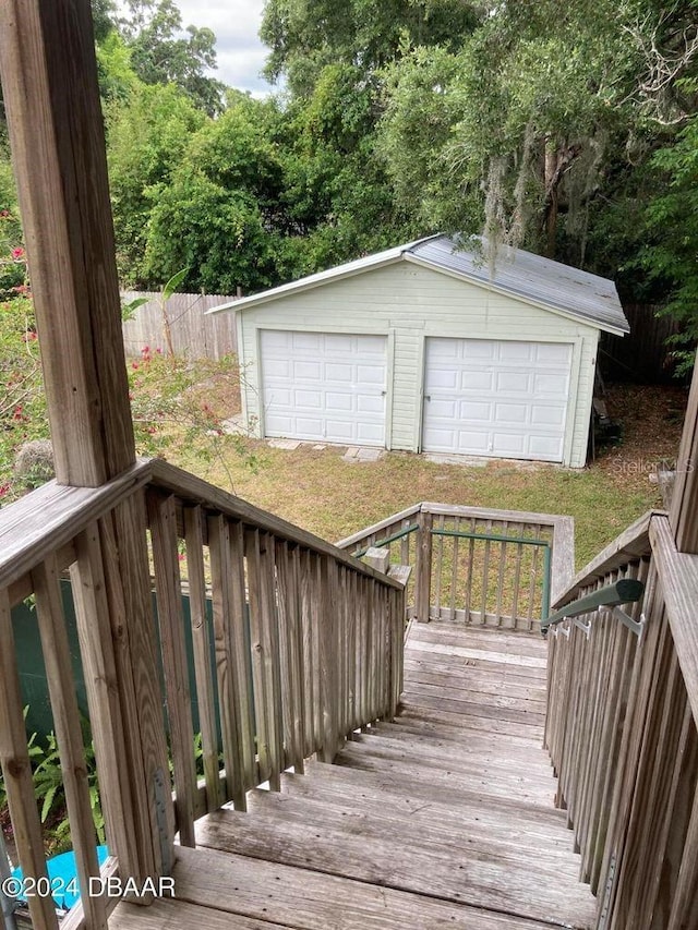 wooden deck featuring a garage and an outdoor structure