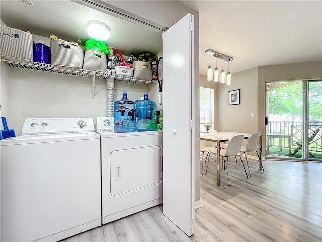 clothes washing area featuring independent washer and dryer and light hardwood / wood-style flooring