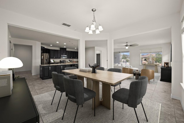 tiled dining space with ceiling fan with notable chandelier