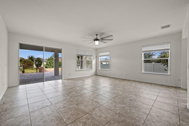 tiled empty room featuring ceiling fan