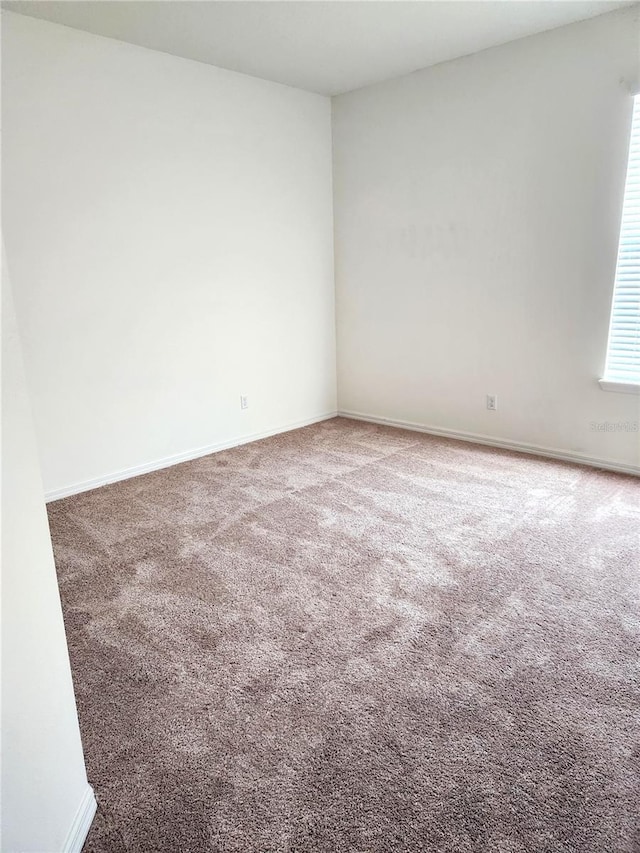 unfurnished room with carpet flooring and plenty of natural light