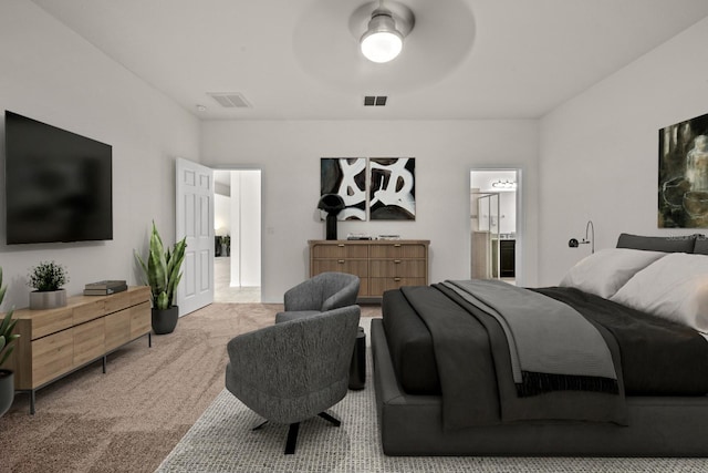 bedroom featuring ensuite bathroom, ceiling fan, and light carpet