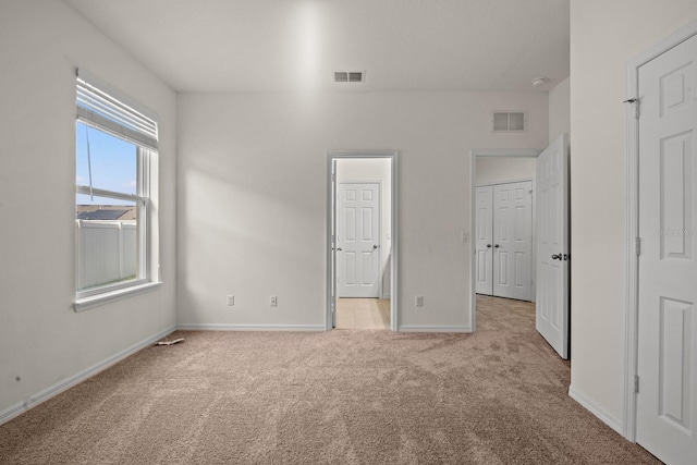 unfurnished bedroom featuring light carpet