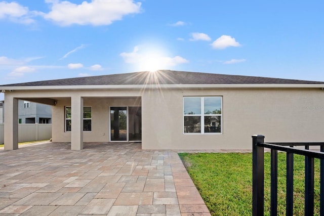 rear view of property featuring a patio and a lawn