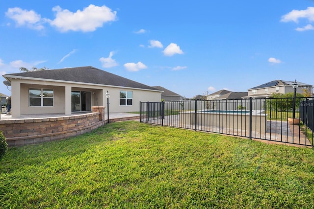 back of property with a lawn and a patio area