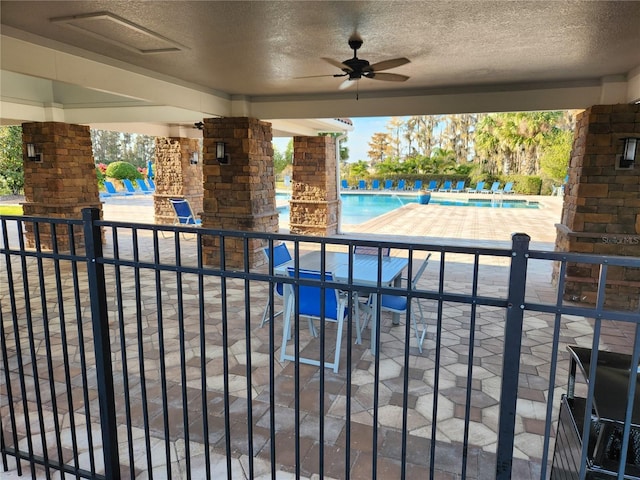 view of swimming pool featuring a patio and ceiling fan