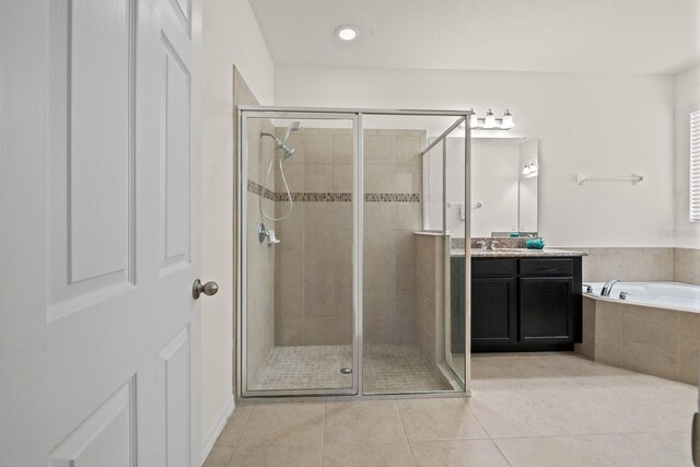 4032 Prairie Reserve Blvd, Orlando, FL 32824 - bathroom featuring a shower stall, tile patterned floors, vanity, a garden tub, and recessed lighting