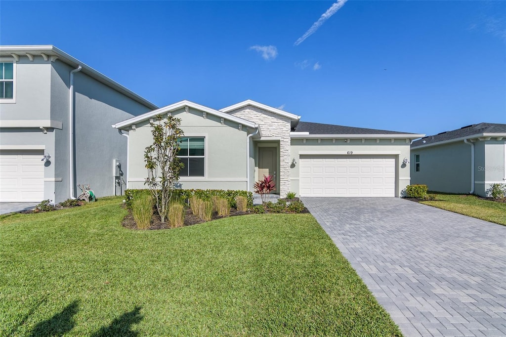 ranch-style home featuring a garage and a front yard