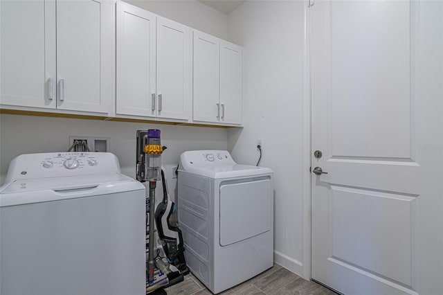 washroom with cabinets and washing machine and dryer