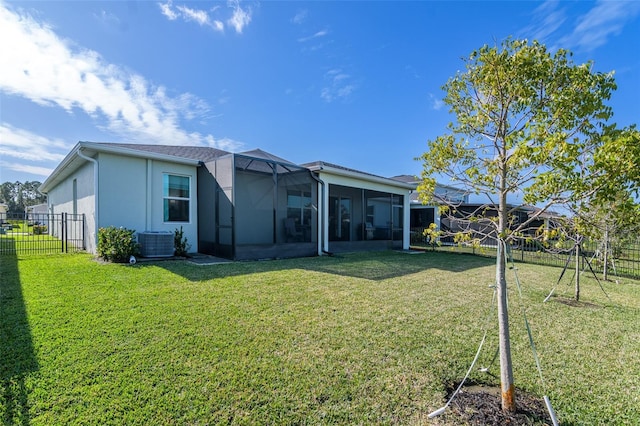 back of house featuring a sunroom, a lanai, a lawn, and central air condition unit