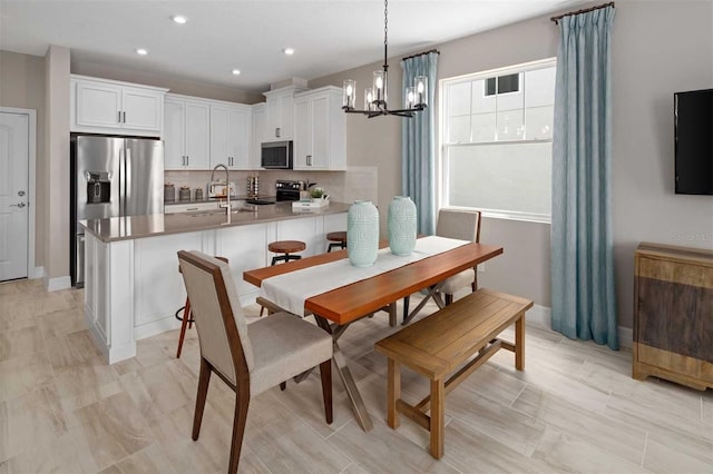 dining space with a notable chandelier and sink