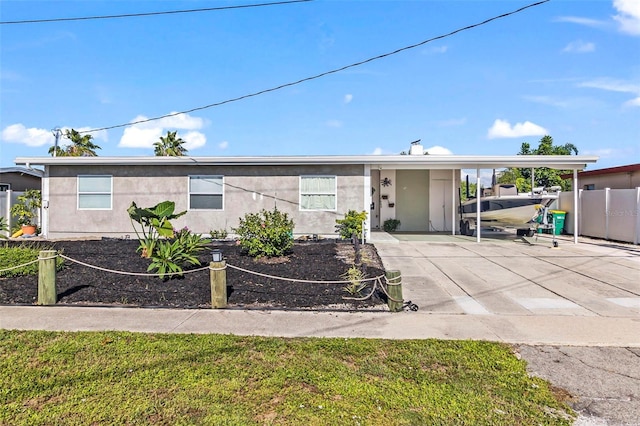 ranch-style house featuring a carport and a front lawn