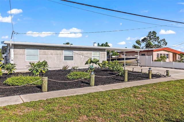 view of front of property featuring a carport and a front lawn