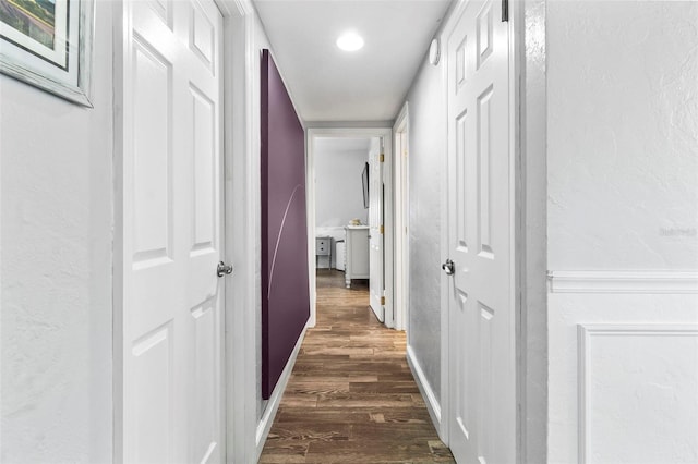 corridor with dark hardwood / wood-style flooring