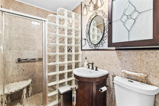 bathroom with vanity, toilet, walk in shower, and tile walls