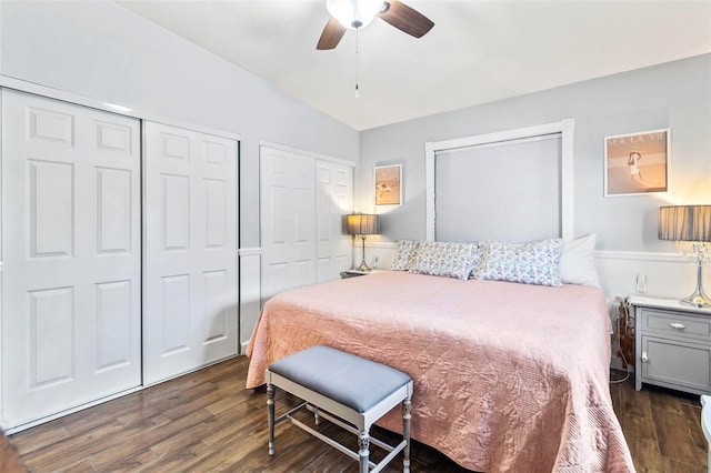 bedroom with two closets, vaulted ceiling, ceiling fan, and dark hardwood / wood-style floors