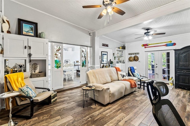 living room with french doors, lofted ceiling with beams, ceiling fan, ornamental molding, and wood-type flooring