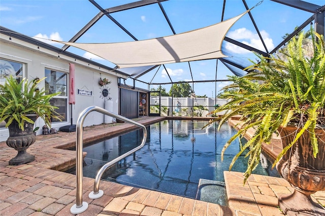 view of pool with glass enclosure and a patio area