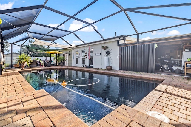 view of pool featuring glass enclosure and a patio