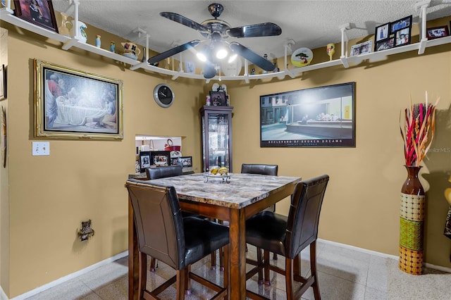 2868 N Powers Dr Unit 5, Orlando, FL 32818 - dining area featuring light speckled floor, a textured ceiling, baseboards, and a ceiling fan