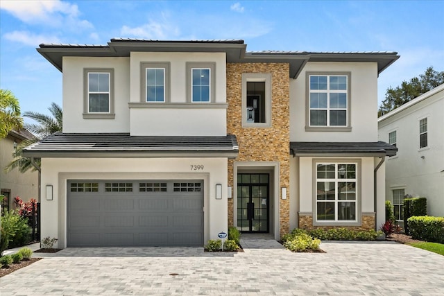 view of front facade featuring stucco siding, decorative driveway, stone siding, and a garage