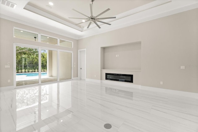 unfurnished living room with visible vents, marble finish floor, a glass covered fireplace, recessed lighting, and a raised ceiling