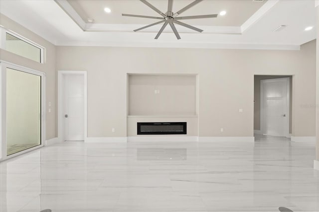unfurnished living room with a raised ceiling, baseboards, and marble finish floor