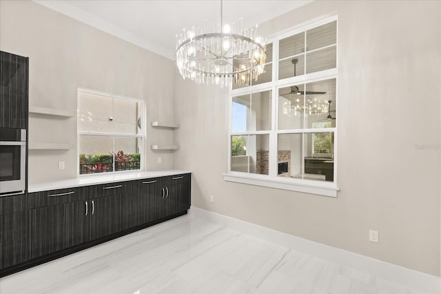 dining room with an inviting chandelier, baseboards, a healthy amount of sunlight, and marble finish floor