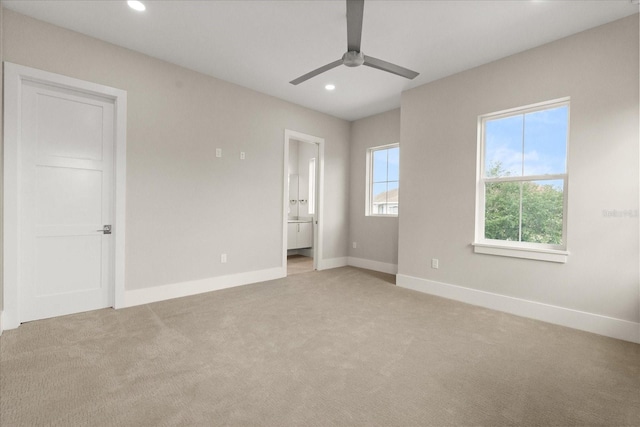 unfurnished bedroom with connected bathroom, light carpet, recessed lighting, baseboards, and a ceiling fan