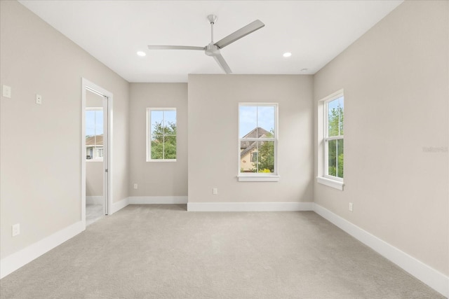 spare room featuring light carpet, a ceiling fan, and recessed lighting