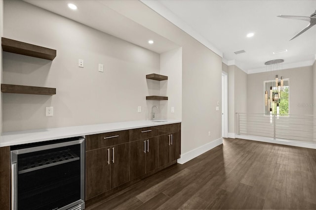 bar with crown molding, beverage cooler, recessed lighting, baseboards, and dark wood-type flooring