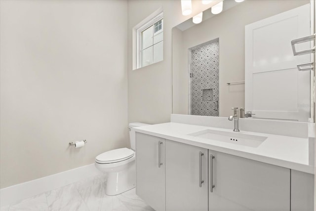 bathroom featuring baseboards, marble finish floor, toilet, and vanity